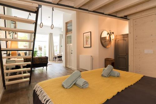 a bedroom with a large bed with a yellow blanket at Studio Jan Steen in Amsterdam