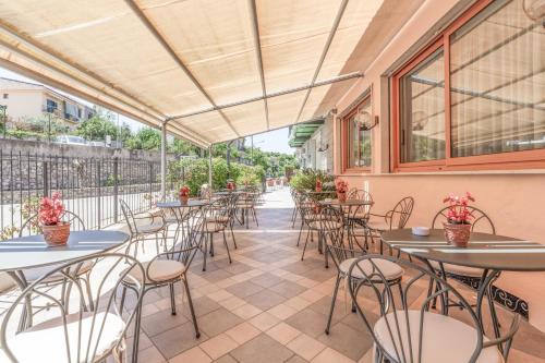 a row of tables and chairs on a patio at Hotel La Pergoletta in SantʼAgata sui Due Golfi