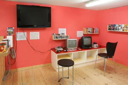 a red wall with two chairs and a tv at Appartement Flora in Saas-Almagell