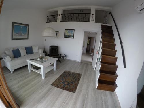 a living room with a stairway and a white couch at Loft Infinity in Petrovac na Moru
