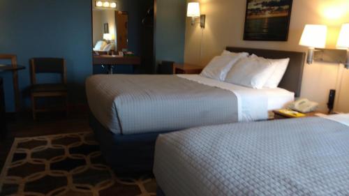 a hotel room with two beds and a table with a phone at Village Inn on the Lake in Two Rivers
