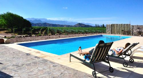 a man and a child laying in a chair next to a pool at Chañarmuyo Casa de Huéspedes in Chañarmuyo