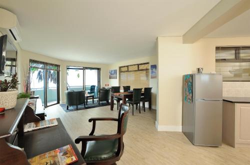 a kitchen and dining room with a refrigerator and tables at Beach Hotel Swakopmund in Swakopmund