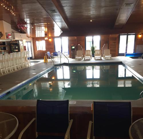 a large swimming pool in a building with chairs at Village Inn on the Lake in Two Rivers