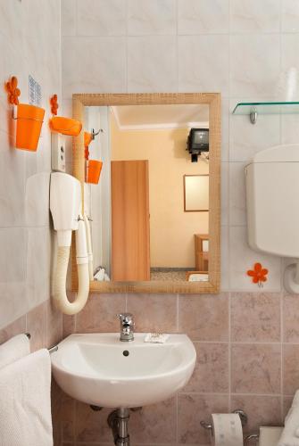 a bathroom with a sink and a mirror at Hotel Grappoli in Rimini