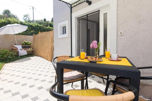 Una mesa y sillas negras en un patio. en Apartman Marija 218, en Risika