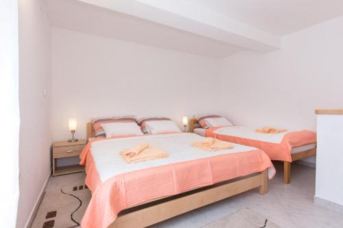 two beds in a room with white walls at Apartman Marija 218 in Risika
