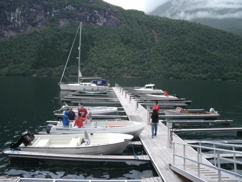 a group of boats docked at a dock in the water at Naustloftet in Hornindal