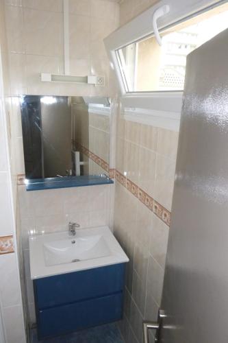 une salle de bain avec un lavabo, un miroir et une fenêtre dans l'établissement Appart proche plage Nausicaa, à Boulogne-sur-Mer