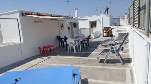 a patio with chairs and tables on a building at Salento - Casa vacanza di Diana Carcagni in Nardò