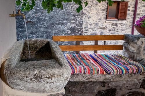 a bench with a blanket sitting next to a building at ARISTIDIS'S PLOUTI MOIRES in Ploutí