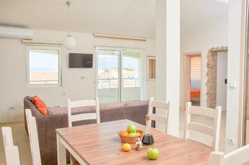 a dining room and living room with a table and chairs at Apartmani Tripović in Tivat