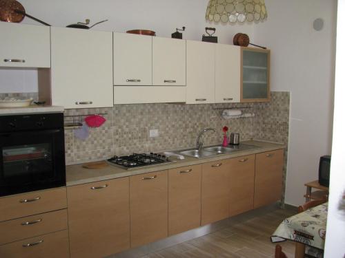 a kitchen with white cabinets and a sink at GranSasso Dream House in Carapelle Calvisio