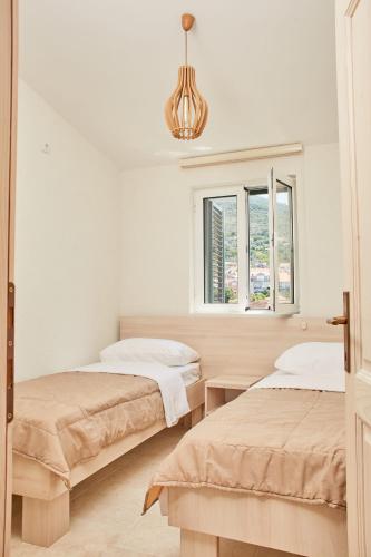 a bedroom with two beds and a chandelier at Apartmani Tripović in Tivat