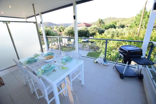 a white table and chairs on a balcony with a grill at V Luxury Suites Toroni 1 in Toroni