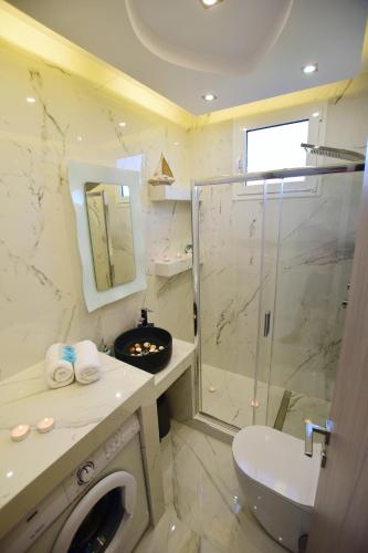 a bathroom with a shower and a washing machine at V Luxury Suites Toroni 1 in Toroni