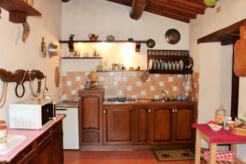 La cuisine est équipée de placards en bois et d'un four avec plaques de cuisson. dans l'établissement Casa San Francesco, à Radicofani