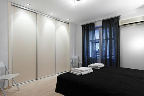 um quarto com uma cama preta e uma janela em Flatsforyou Sorolla House em Valência