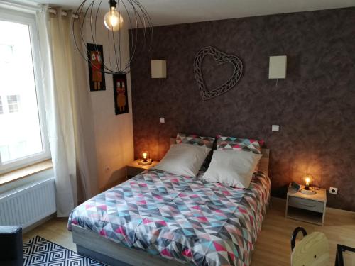 a bedroom with a bed with a heart on the wall at Le Centrale in Gérardmer