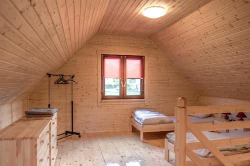 eine Blockhütte mit 2 Etagenbetten und einem Fenster in der Unterkunft Domki Wczasowe Mielenko in Mielenko
