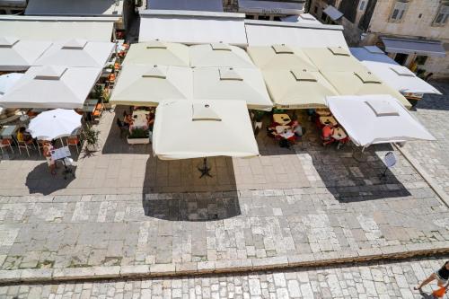 an overhead view of a patio with white umbrellas at Kolbe Hvar Piazza Apartment in Hvar