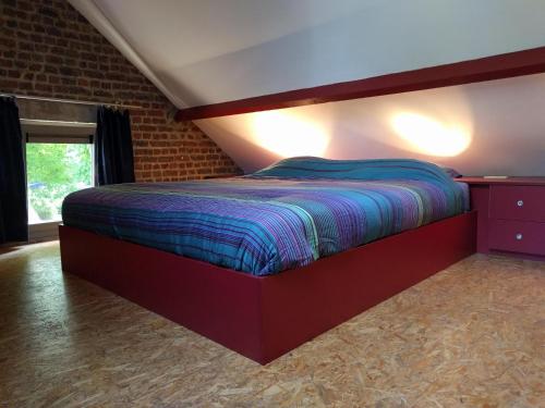 Un dormitorio con una cama en una pared de ladrillos. en Wolfshaegen 180, en Huldenberg
