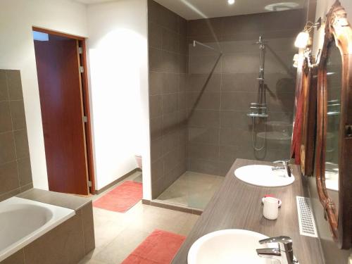 a bathroom with two sinks and a tub and a shower at Wolfshaegen 180 in Huldenberg