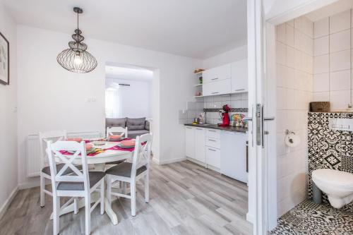 une cuisine et une salle à manger avec une table et des chaises dans l'établissement Lawendowe domki apartamenty, à Władysławowo