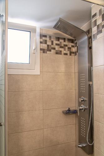a bathroom with a shower with a window at Lazaros Home in Palekastron
