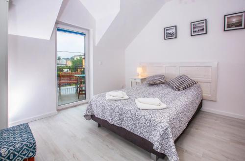 une chambre avec un lit avec deux serviettes dessus dans l'établissement Lawendowe domki apartamenty, à Władysławowo