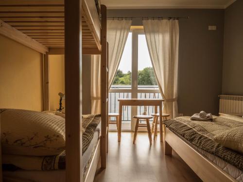 sypialnia z 2 łóżkami i stołem oraz balkonem w obiekcie Pokoje U Solany w mieście Knurów