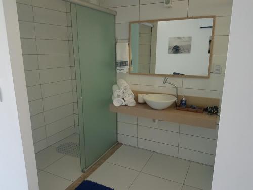 a bathroom with a sink and a mirror at Solar Água - Apto. 114 in Pipa