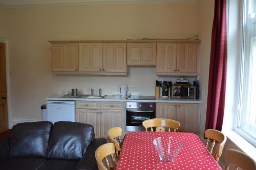 a kitchen with a table with a red and white polka dot table cloth at Hargate Hall Self Catering in Buxton