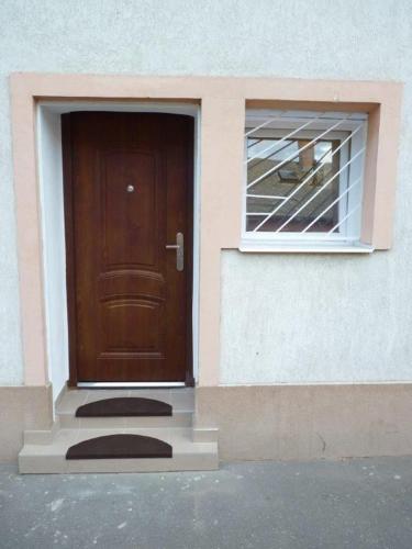 a brown door and a window on a building at Eper Apartman in Debrecen