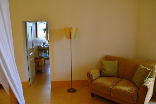 a living room with a couch and a floor lamp at Relais Masseria Villa Cenci in Cisternino