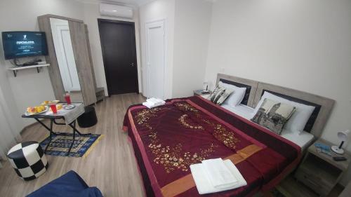 a bedroom with a large bed and a table at Villa Royal House in Makhinjauri