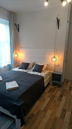 a bedroom with a large bed with two lamps on it at Tawerna Rybaki Old Town in Gdańsk