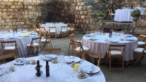 a group of tables with wine glasses and wine bottles at Castillo de Grisel in Grisel