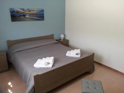 a bedroom with a bed with two towels on it at Villa Fiorella in Sciacca