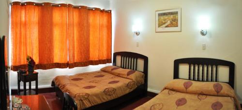 a bedroom with two beds and a window at Hotel 5a Avenida in Monterrey