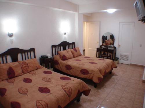 Una cama o camas en una habitación de Hotel 5a Avenida