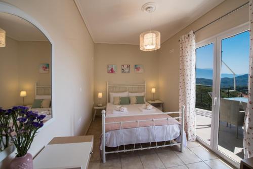 a bedroom with a bed and a balcony at Villa Amolena in Kariá