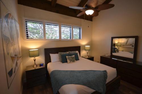 a bedroom with a bed and a ceiling fan at Papakea #H401 in Lahaina