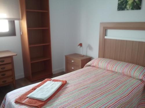 a bedroom with a bed with a towel on it at Apartamento Teatinos Málaga in Málaga