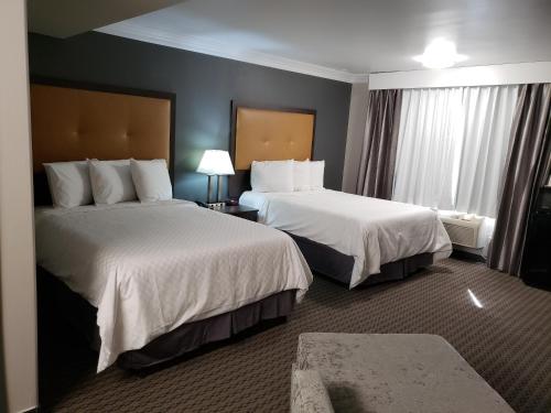 una camera d'albergo con due letti e una finestra di Portofino Inn Burbank a Burbank