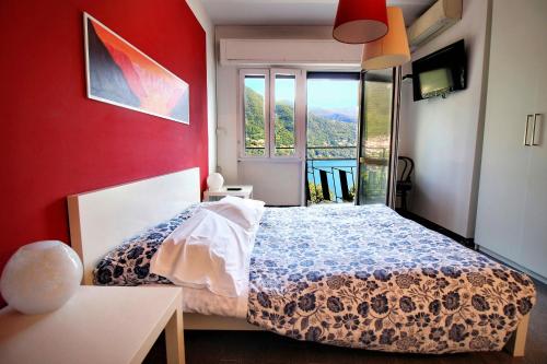 a bedroom with a bed and a large window at Hotel Bersagliere in Laglio