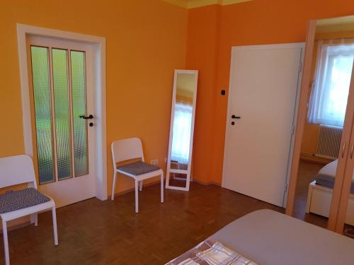 a room with two chairs and a bed and two doors at Garden Apartment Donau-City (P&R) in Vienna