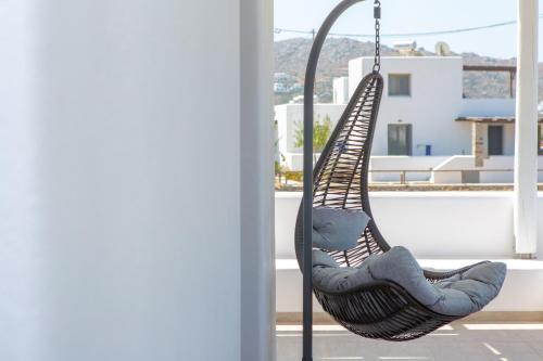a swing on a balcony with a view of a building at Salinus Beachfront Private Pool Villas in Plaka