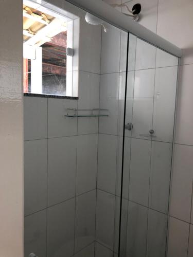 a glass shower in a bathroom with a window at Kitnet Central II in Arraial do Cabo