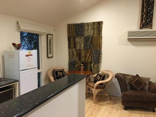 a kitchen with a white refrigerator and a table and chairs at Weeroona Bed And Breakfast in Rye